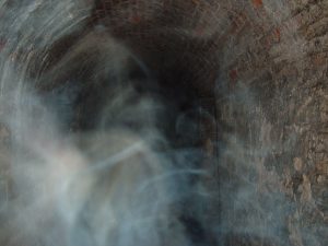 Candle smoke interacting in cold damp air.